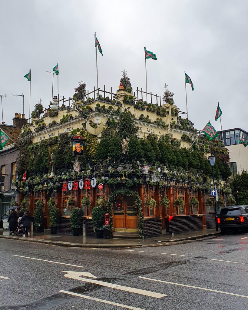 A pub in London, England that has Christmas trees all over it with a sign that says "HoHoHo" down the bottom "How to Have the Best Time in London (For Free!)"