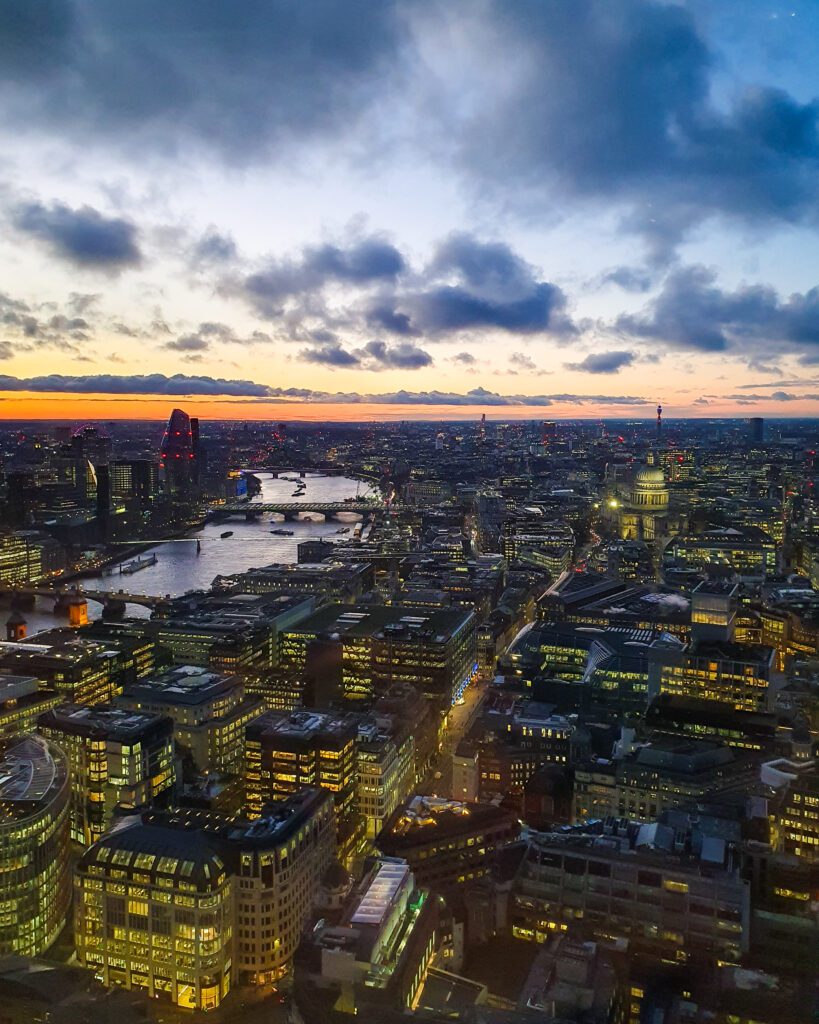 A view from the Sky Garden in London, England. The view is over London and the Thames river all lit up in the evening "How to Have the Best Time in London (For Free!)"