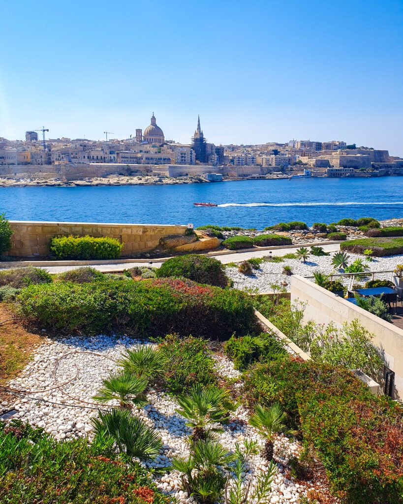 A view of Valletta from Sliema in Malta across the blue water where you can see a big church with a dome on top "Where Are the Best Areas to Stay in Malta?"