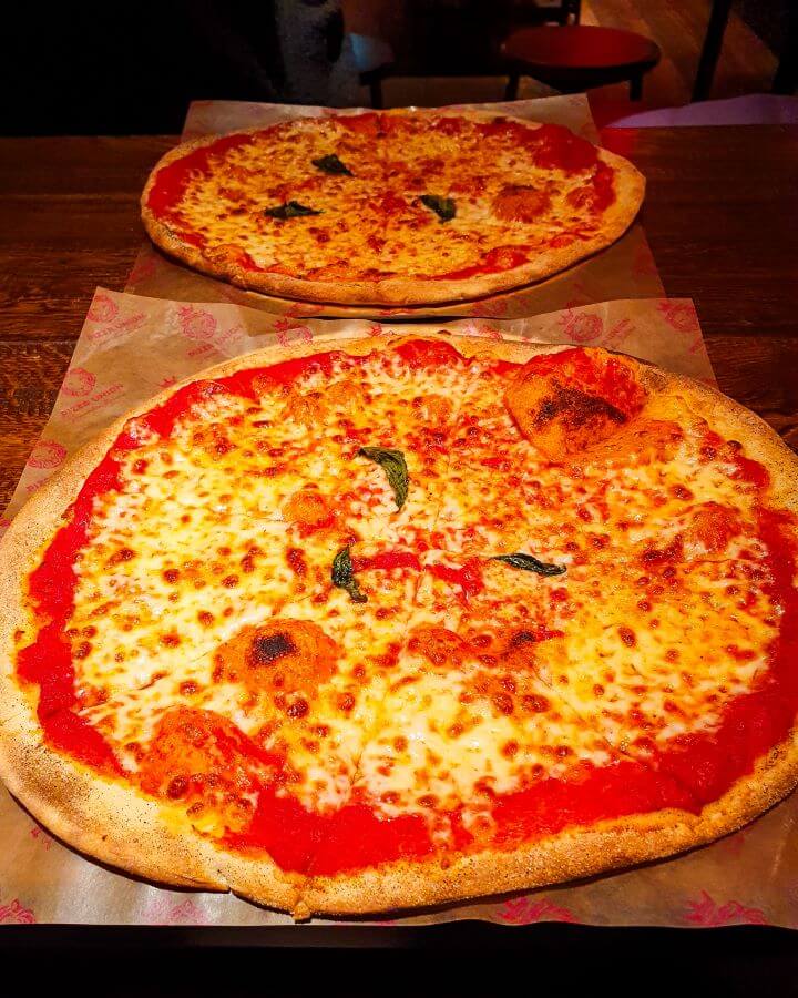 Two pizzas with tomato sauce, cheese and basil. They've got thin crispy bases and are from Pizza Union in London, England "Three Great Hacks To Save Money In London"