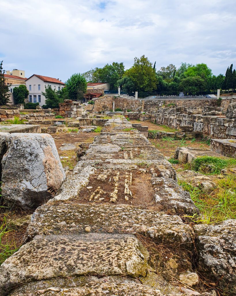 A big patch of grass with lots of huge stone ruins and trees around the ruins in Athens, Greece "How to Make the Most of the Athens Combined Ticket"