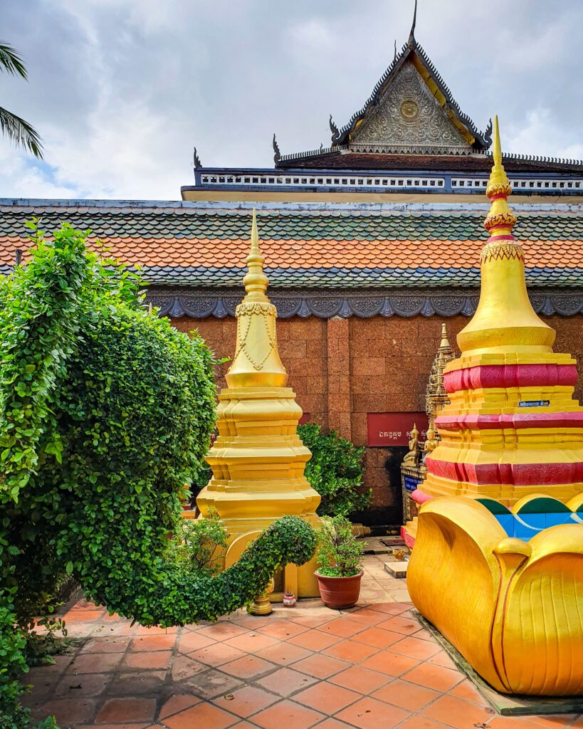 Some gold spires in the Wat Bo temple in Siem Reap Cambodia. There is also a bit of a plant that is cut into the shape of a head of an elephant "The Ultimate Guide to Siem Reap: Temples, Markets, and More!"