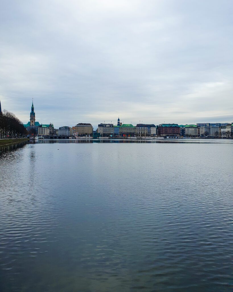 A a view of Binnenalster or the Inner Alster Lake in Hamburg, Germany. Around the lake are some beautiful European buildings "How to See Hamburg on a Budget"