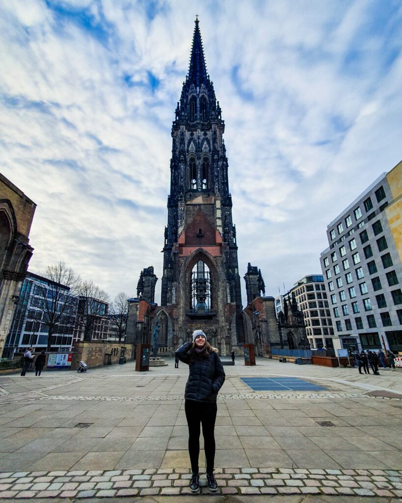 Katherine standing in front of the tall and impressive St. Nikolai Memorial in Hamburg, Germany "How to See Hamburg on a Budget"